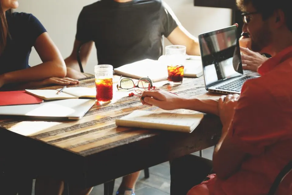 Entrepreneurs échangeant autour d’une table de travail